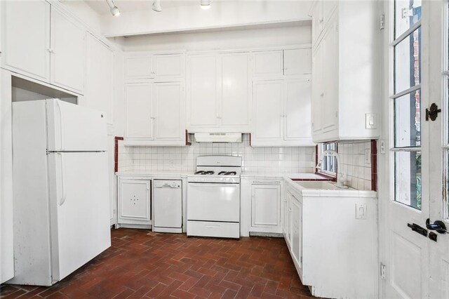 kitchen featuring white cabinets, range, exhaust hood, white refrigerator, and sink