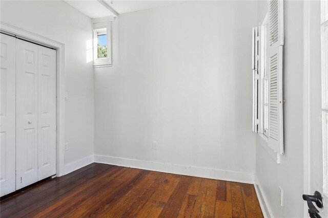 unfurnished bedroom featuring a closet and dark hardwood / wood-style flooring