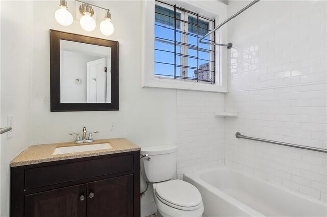 full bathroom with toilet, vanity, and tiled shower / bath