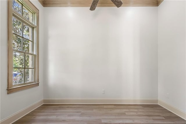 empty room with crown molding, ceiling fan, and light wood-type flooring