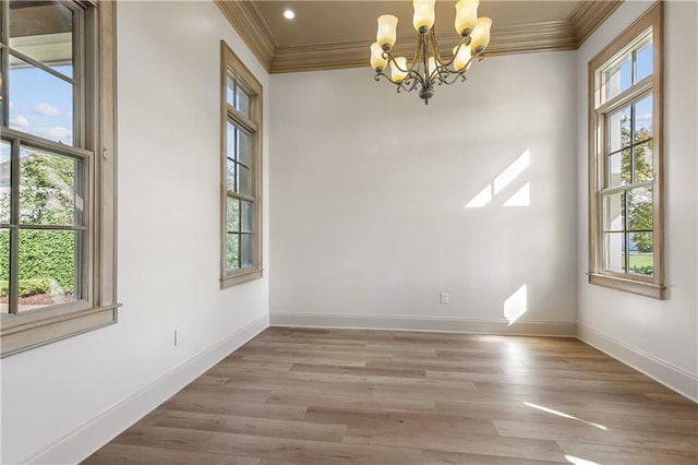 unfurnished dining area with ornamental molding, a notable chandelier, and light hardwood / wood-style floors