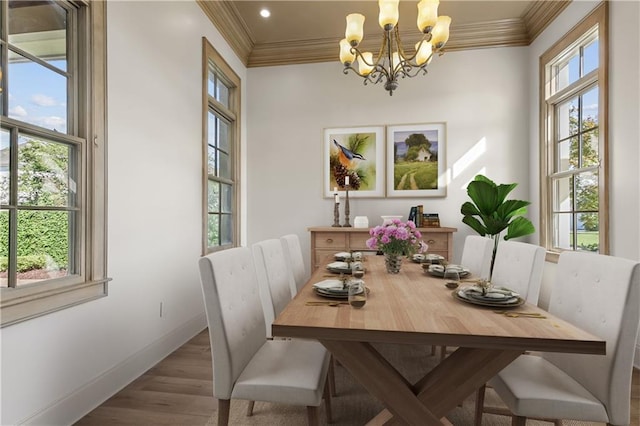 dining space featuring an inviting chandelier, crown molding, and hardwood / wood-style flooring