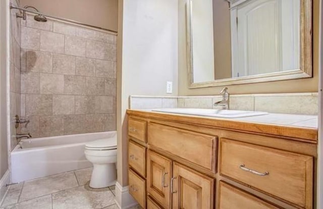 full bathroom featuring vanity, tiled shower / bath combo, tile patterned floors, and toilet