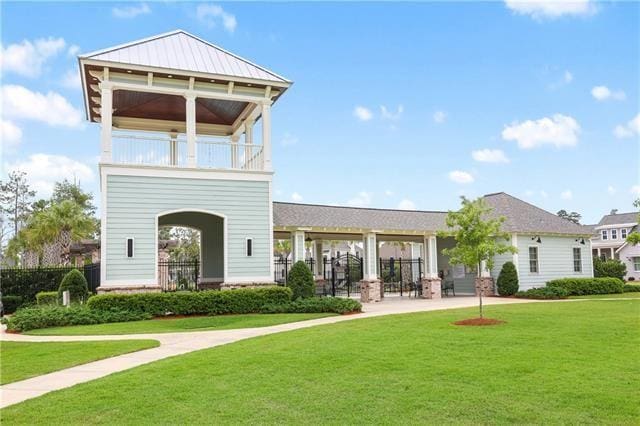 rear view of property featuring a yard and a balcony