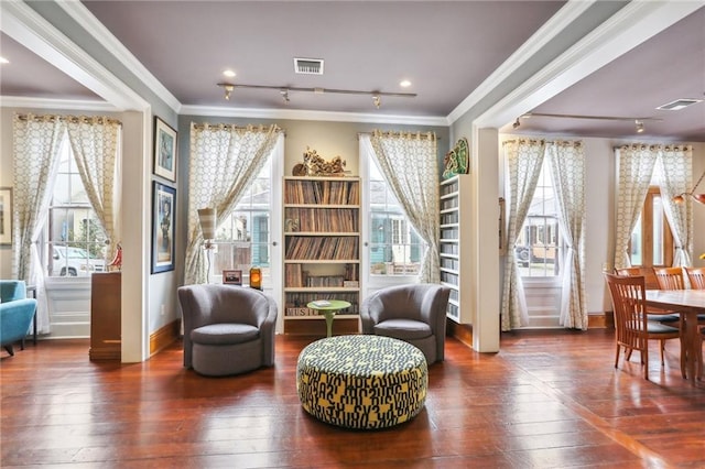 living area featuring crown molding, plenty of natural light, and dark wood-type flooring