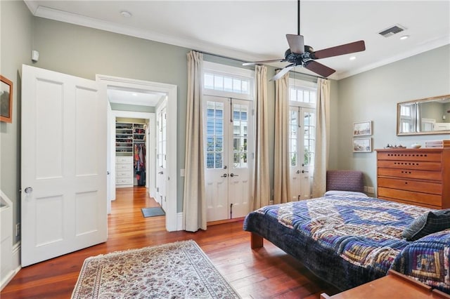 bedroom featuring hardwood / wood-style flooring, ceiling fan, crown molding, and french doors