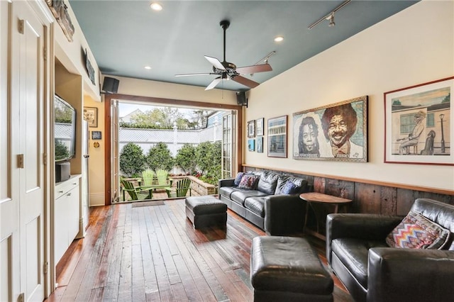 living room featuring hardwood / wood-style flooring, rail lighting, and ceiling fan