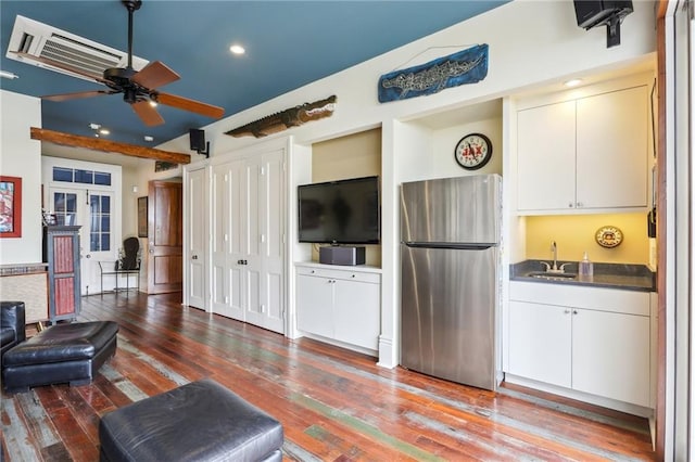 living room featuring wood-type flooring, wet bar, and ceiling fan