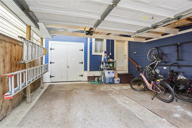 garage featuring a garage door opener and wood walls