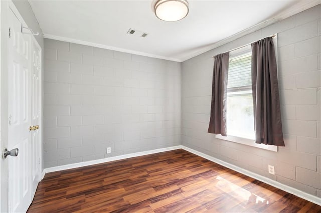 empty room with ornamental molding and dark hardwood / wood-style flooring