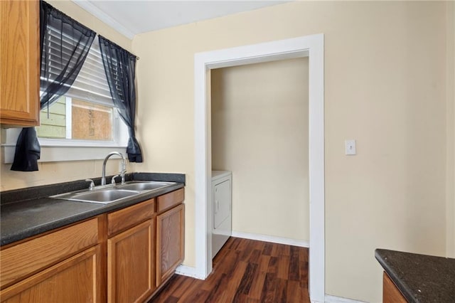 kitchen featuring dark hardwood / wood-style flooring, sink, and washer / clothes dryer