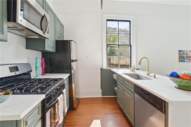 kitchen with stainless steel appliances, sink, and light wood-type flooring