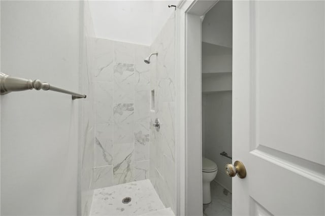 bathroom with toilet and tiled shower