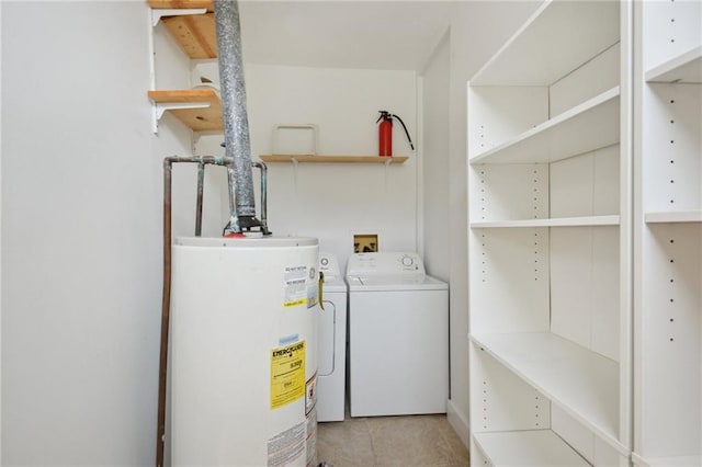 laundry room featuring water heater, light tile patterned floors, and washer and clothes dryer