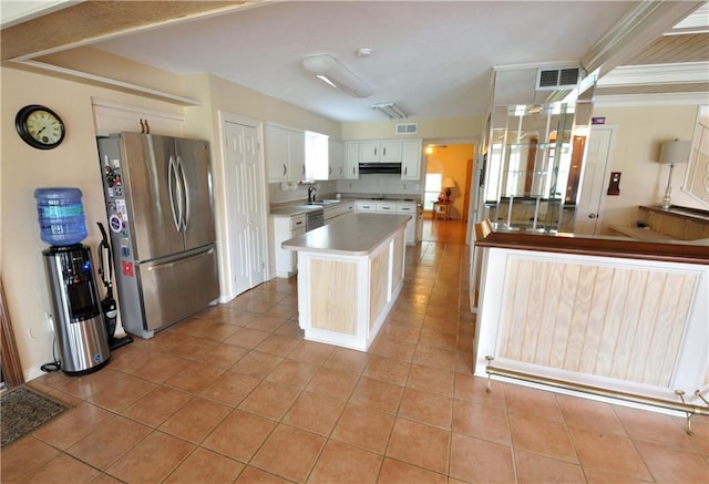 kitchen featuring stainless steel fridge, a kitchen island, sink, white cabinets, and light tile patterned floors