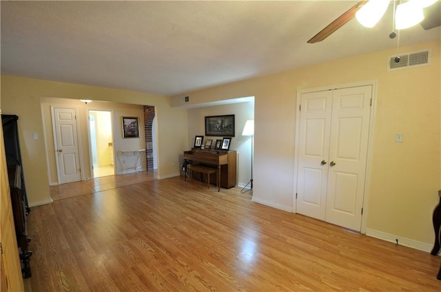 unfurnished living room with ceiling fan and light hardwood / wood-style floors