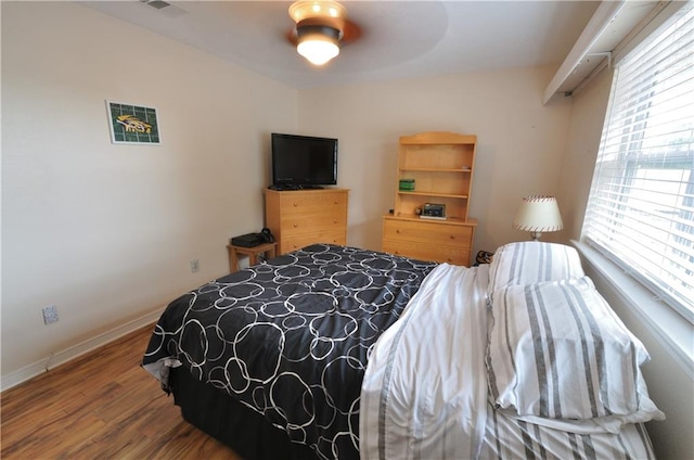 bedroom with wood-type flooring, multiple windows, and ceiling fan