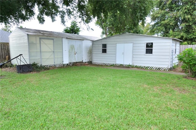 back of house featuring a storage shed and a lawn