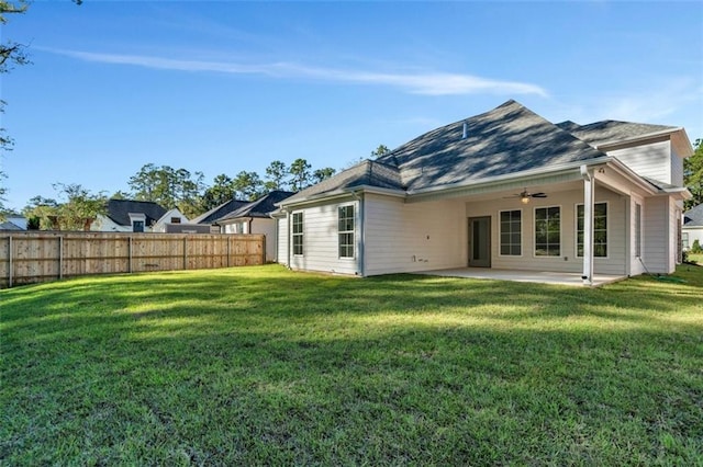 rear view of property featuring a lawn and a patio