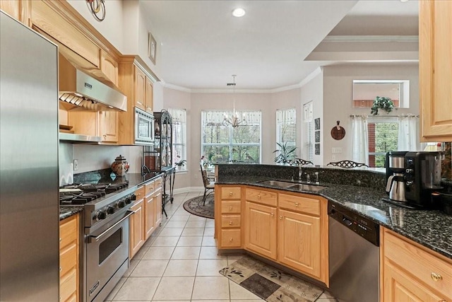 kitchen with appliances with stainless steel finishes, hanging light fixtures, dark stone countertops, and a chandelier