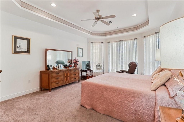 carpeted bedroom featuring a raised ceiling and ceiling fan