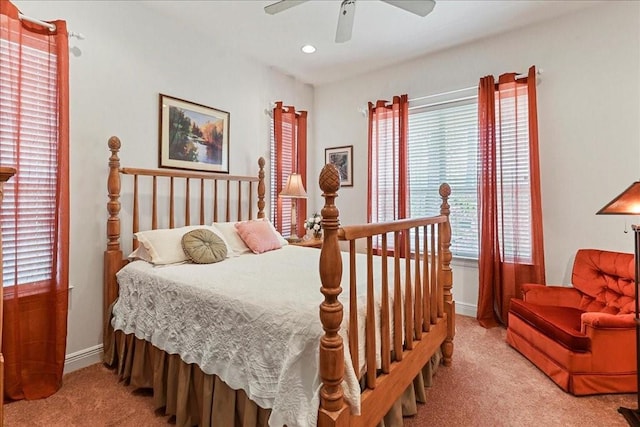 bedroom with ceiling fan, light colored carpet, and multiple windows