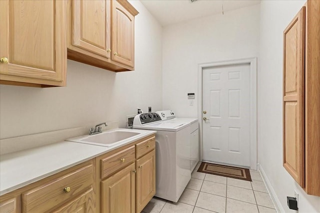 laundry room with cabinets, sink, light tile patterned floors, and washing machine and clothes dryer