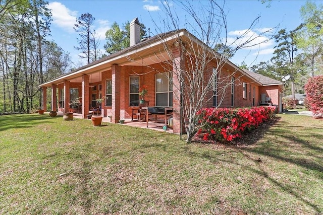 view of side of home featuring a patio area and a yard