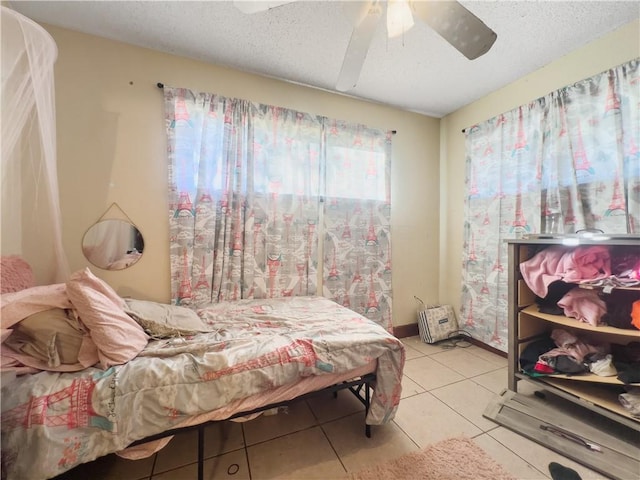 tiled bedroom featuring ceiling fan and a textured ceiling