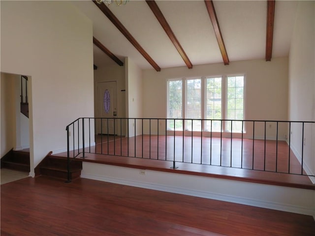 empty room featuring hardwood / wood-style flooring and lofted ceiling with beams