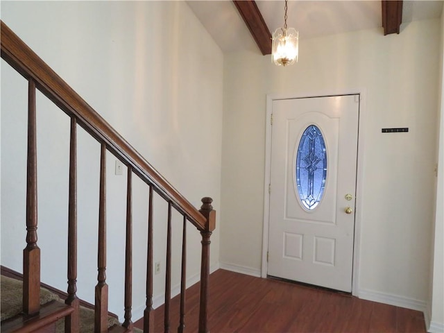 foyer featuring dark hardwood / wood-style floors, an inviting chandelier, and beamed ceiling