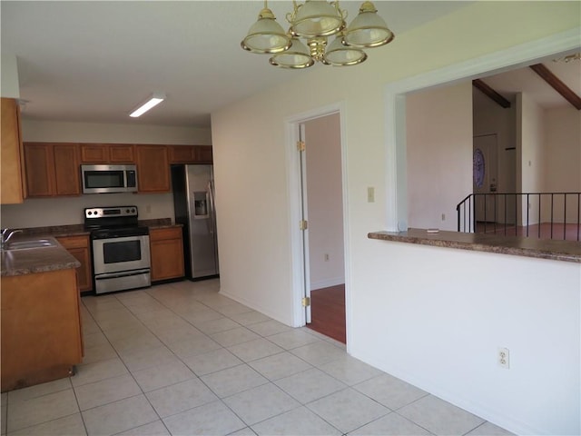 kitchen featuring hanging light fixtures, light tile patterned floors, an inviting chandelier, stainless steel appliances, and sink