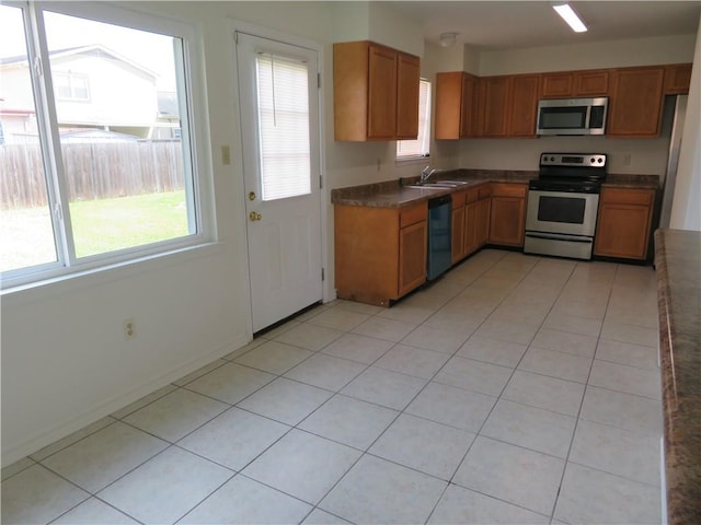 kitchen featuring stainless steel appliances, light tile patterned flooring, and sink