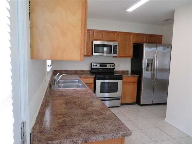 kitchen with light tile patterned floors, stainless steel appliances, and sink