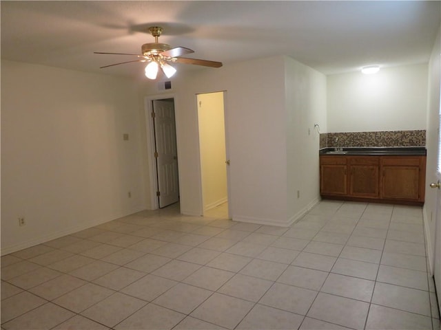 unfurnished room with ceiling fan and light tile patterned floors