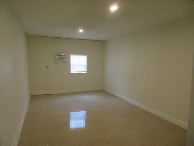 unfurnished room with a wall unit AC and light tile patterned flooring