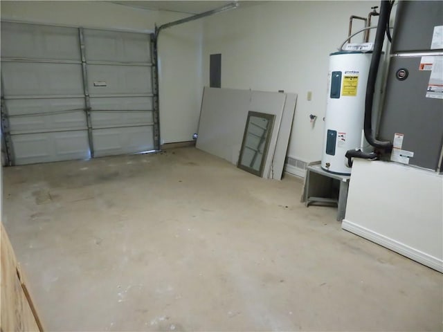 garage featuring heating unit and electric water heater