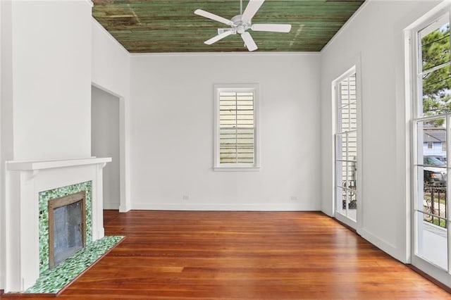 unfurnished living room featuring ceiling fan, a fireplace, plenty of natural light, and hardwood / wood-style floors