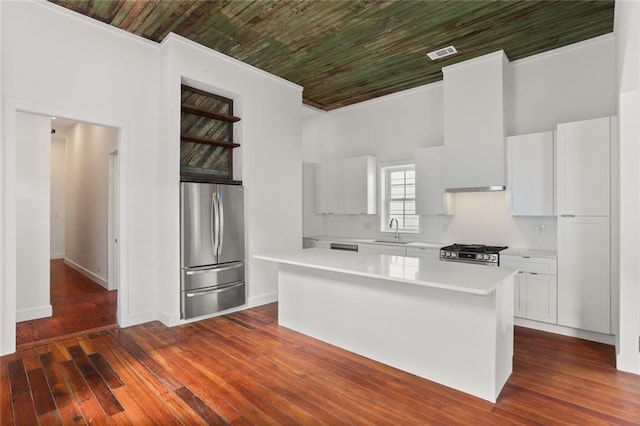 kitchen featuring sink, white cabinets, a kitchen island, appliances with stainless steel finishes, and dark hardwood / wood-style flooring