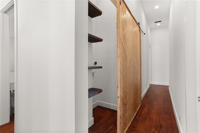 hall featuring a barn door and dark hardwood / wood-style flooring