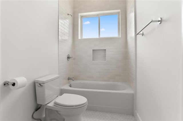 bathroom with tile patterned floors, tiled shower / bath, and toilet