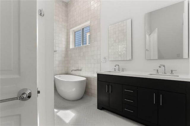 bathroom with tile walls, tile patterned flooring, a bathing tub, and vanity