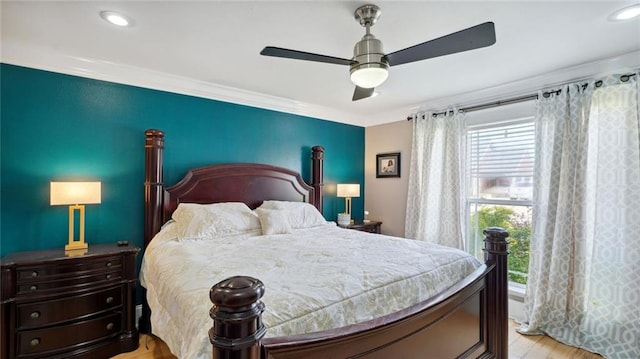 bedroom featuring ceiling fan, crown molding, and light hardwood / wood-style floors