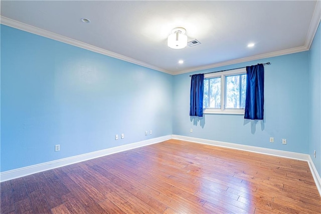 spare room featuring crown molding and hardwood / wood-style flooring