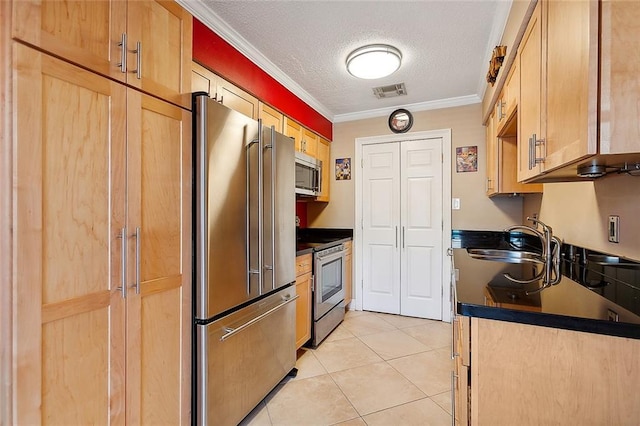 kitchen with sink, ornamental molding, a textured ceiling, light tile patterned flooring, and stainless steel appliances