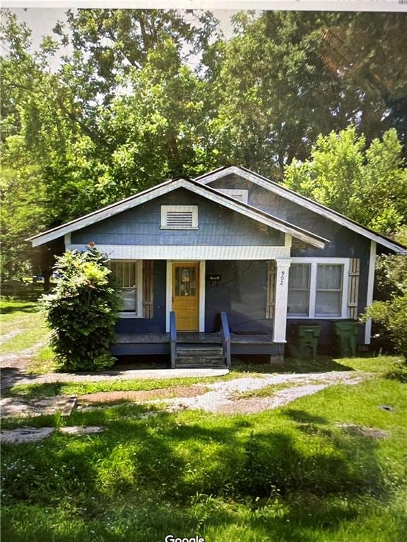 bungalow-style house featuring a front yard and covered porch