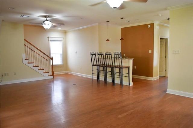 unfurnished room with ceiling fan, ornamental molding, and wood-type flooring