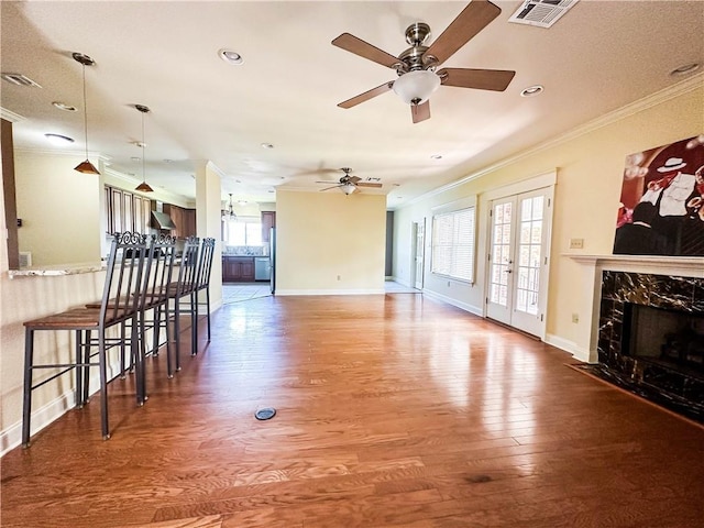 living room featuring ornamental molding, ceiling fan, hardwood / wood-style flooring, and plenty of natural light