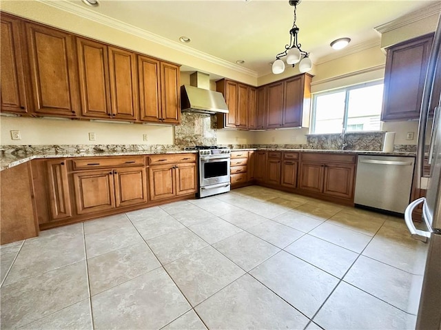 kitchen featuring appliances with stainless steel finishes, wall chimney exhaust hood, light stone countertops, pendant lighting, and crown molding