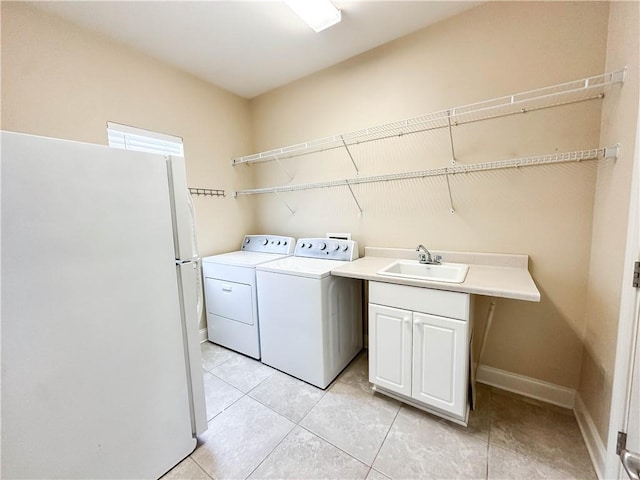 laundry room with washing machine and dryer, light tile patterned flooring, sink, and cabinets